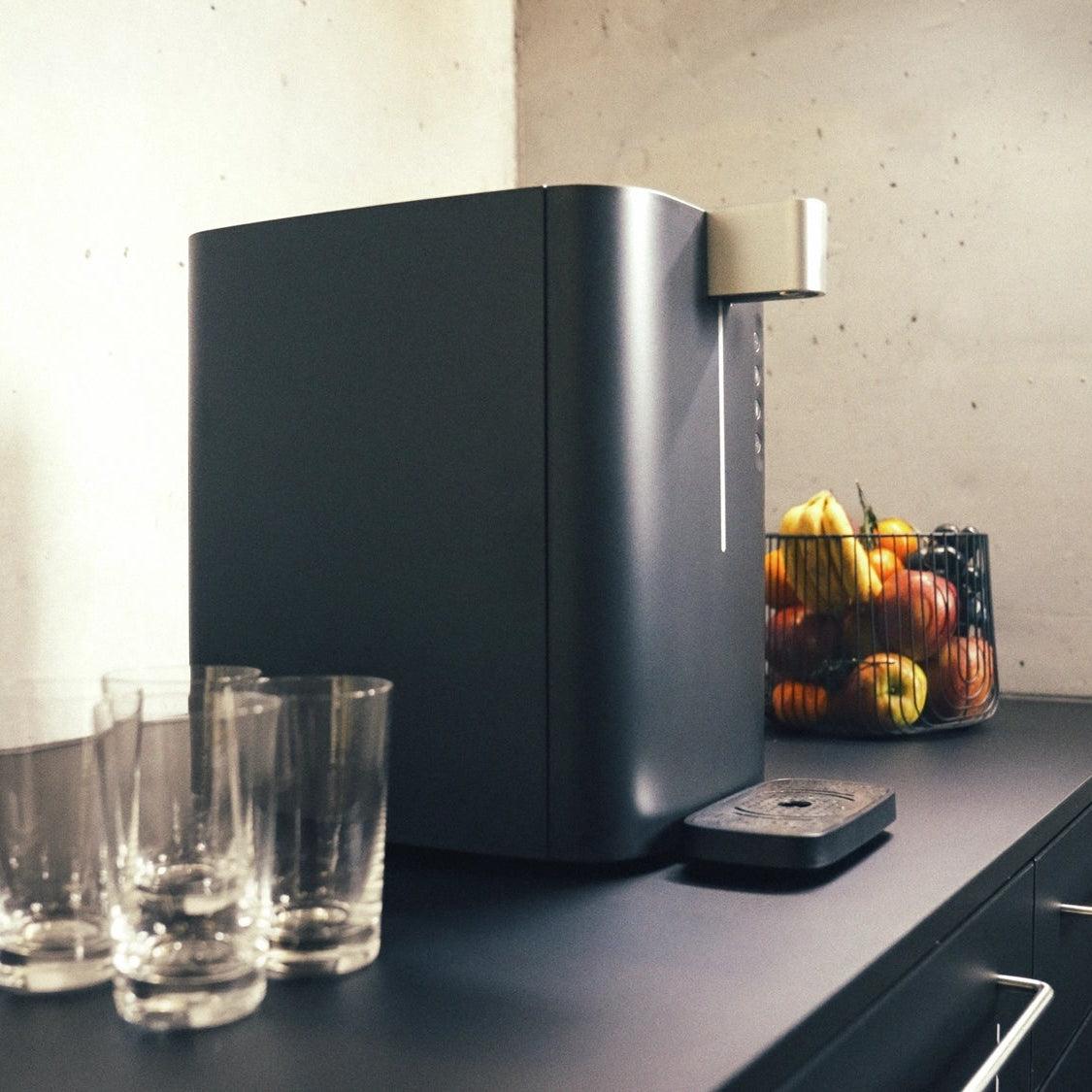 BRITA Top Compact on a kitchen counter with glasses and a fruit basket in the background.